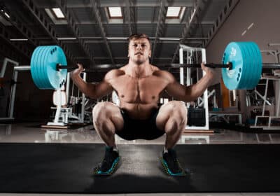 Man performing a deep squat with heavy weights using Flexelent squat wedges