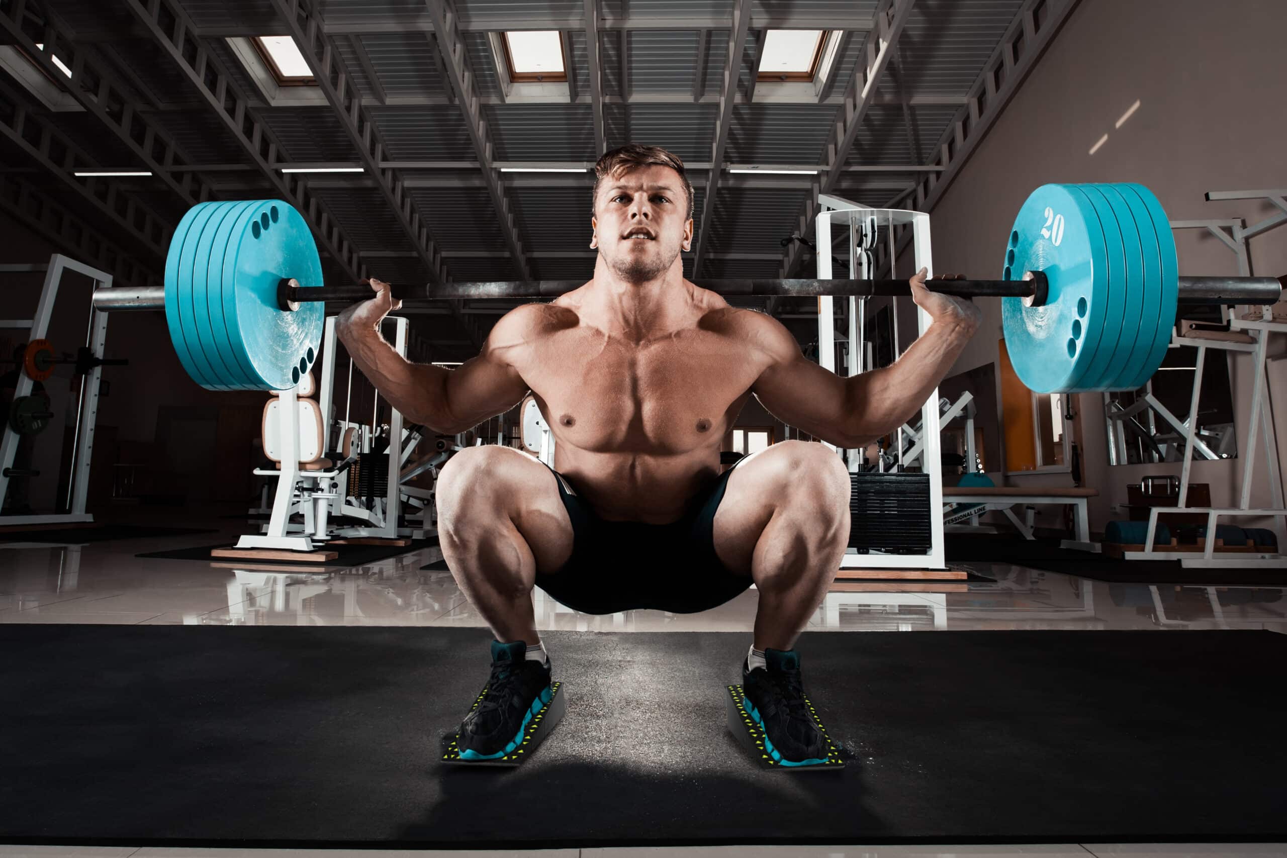 Man performing a deep squat with heavy weights using Flexelent squat wedges